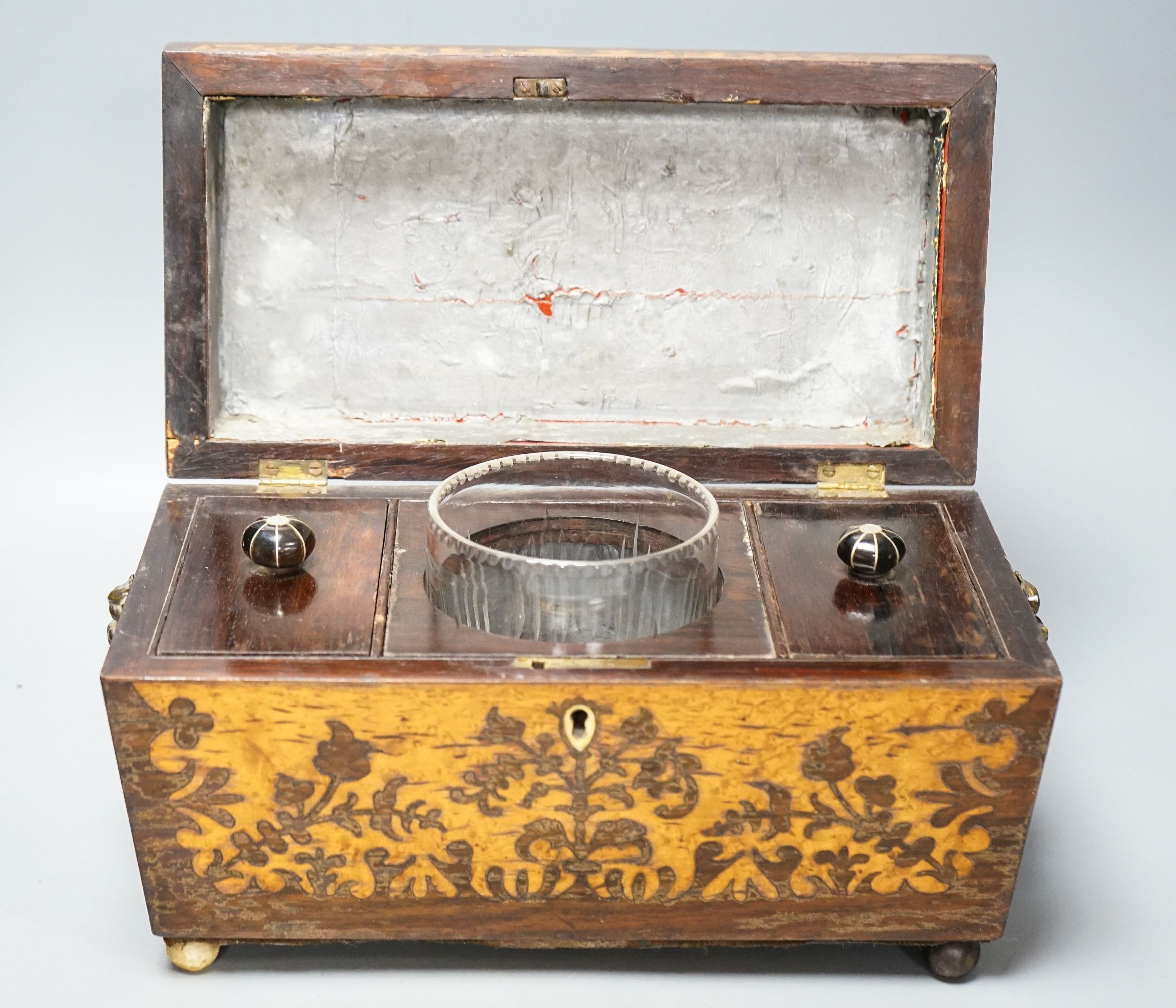 A 19th century rosewood and bird’s eye maple tea caddy, of sarcophagus form, the interior with mixing bowl, on ball feet 31cm